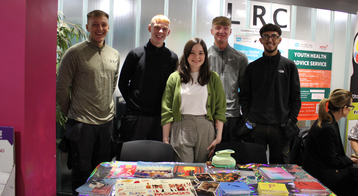 4 students and 1 exhibitor standing behind a table at the SU freshers fair 